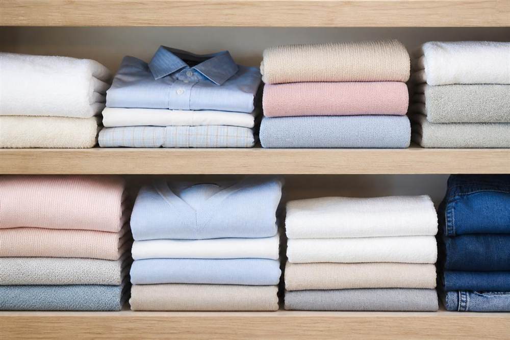Folded shirts and towels on shelves